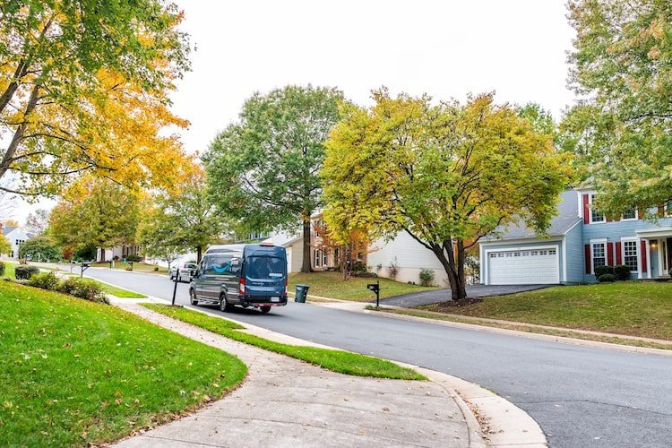 Herndon, USA - October 25, 2019: Northern Virginia Fairfax county residential neighborhood in spring with houses and road with Amazon prime delivery truck car
