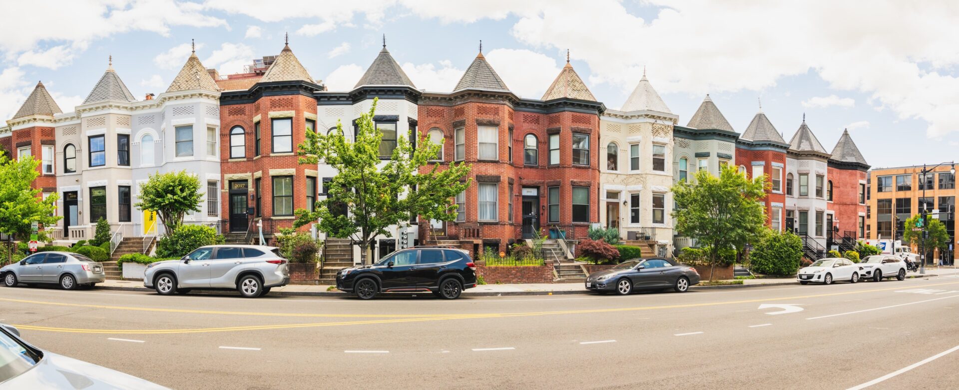 historic row houses with turrets and bay windows line a sunny street in the Adams Morgan neighborhood
